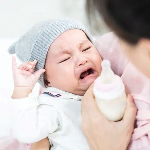 Bebé rechazando un biberón alérgico a la lactosa